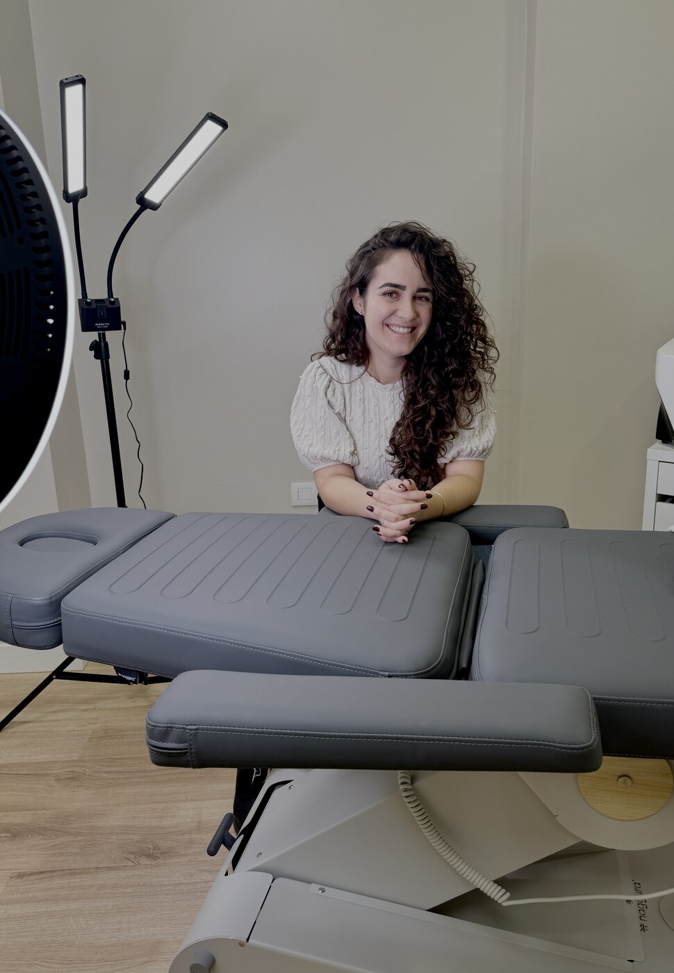 Claudia Acosta beside the micropigmentation treatment bed at Liora Microbeauty