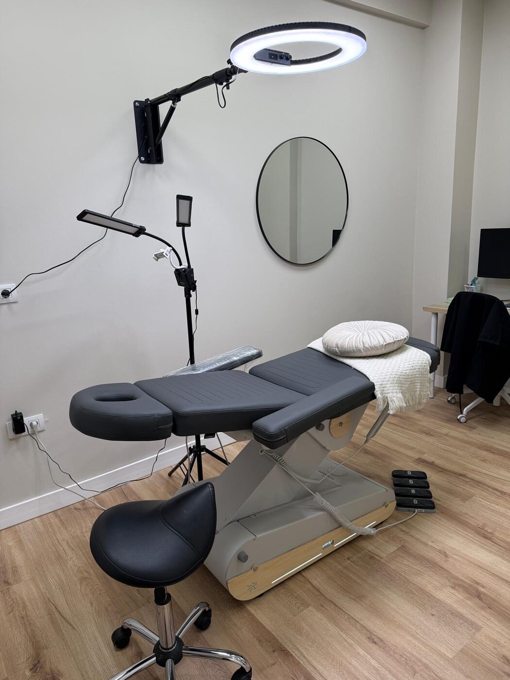 Treatment room with bed and ring light at Liora Microbeauty
